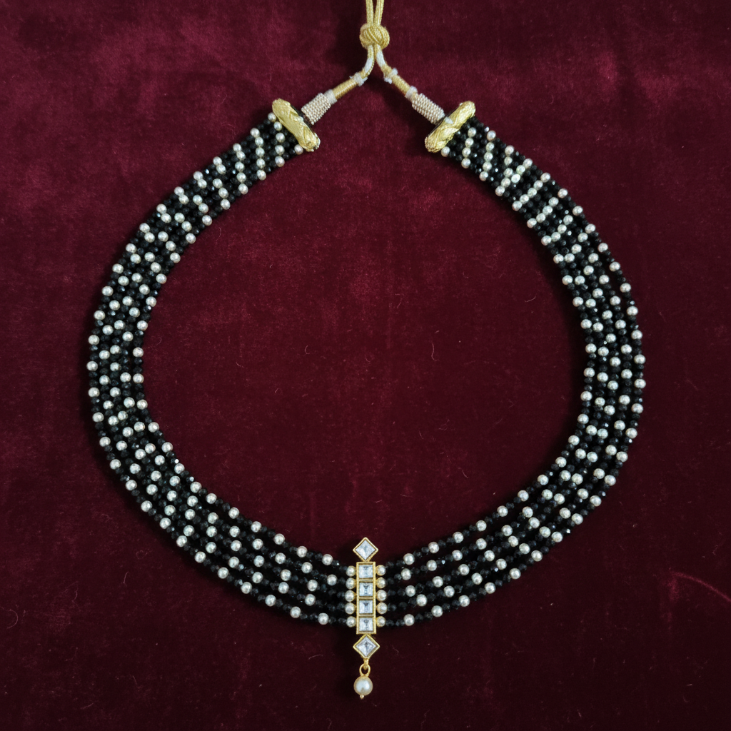Black pearl necklace on burgundy velvet background