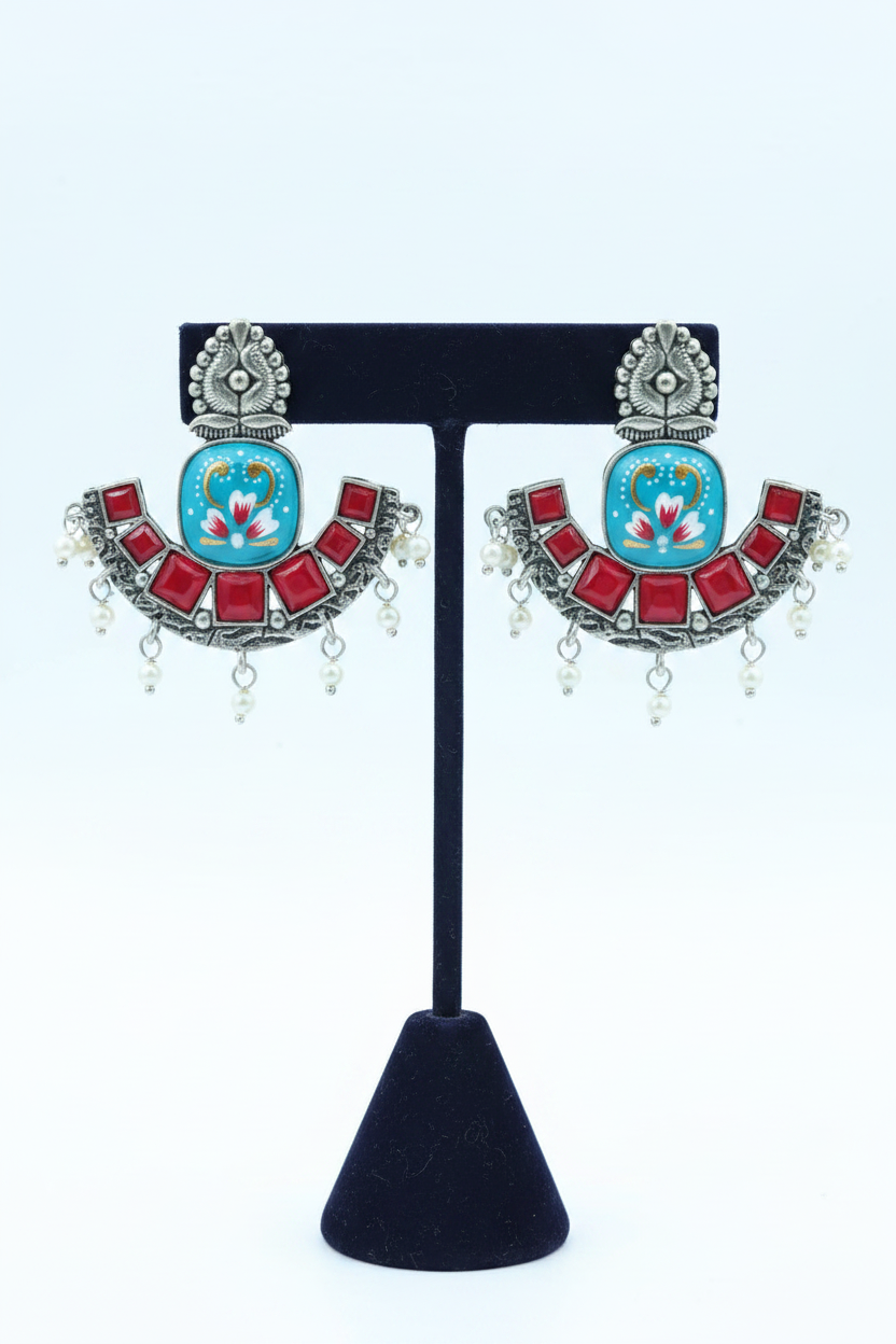 Oxidised silver chandbali earrings on navy blue velvet stand